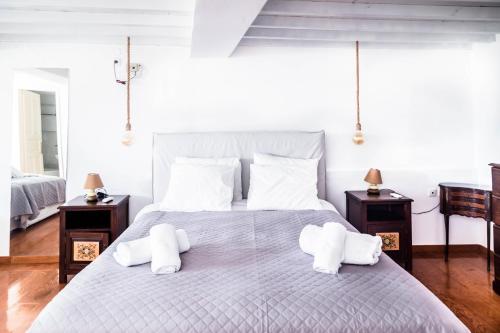 biała sypialnia z dużym łóżkiem i ręcznikami w obiekcie Mykonos Vibes Downtown Townhouse w mieście Mykonos
