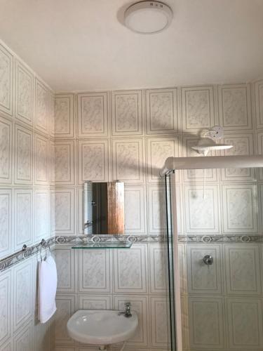 bagno con lavandino e doccia con specchio di Pousada Gira-Sol a São Pedro da Aldeia