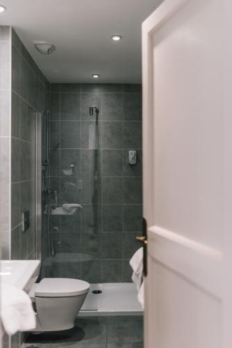 a bathroom with a shower and a toilet and a sink at Hôtel La Résidence in Narbonne