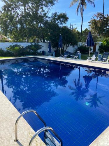 a swimming pool with blue water in a resort at Pousada Vila Novo Tempo in Guarujá