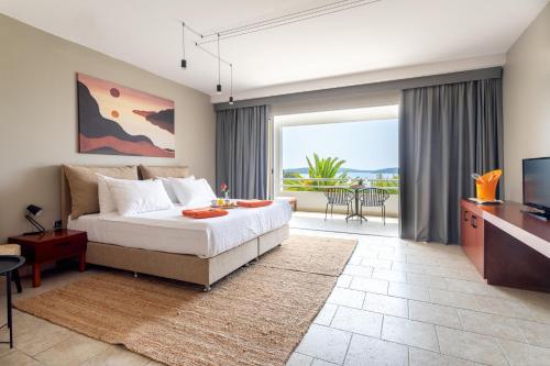 a bedroom with a bed and a tv and a balcony at Hotel Podstine in Hvar