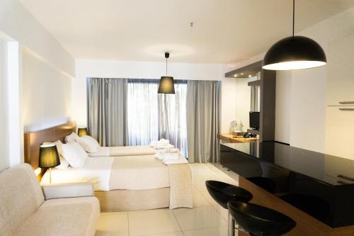 a hotel room with two beds and a couch at City Loft Hotel in Patra