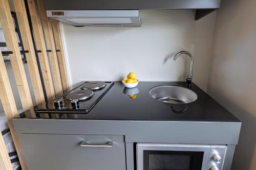 a small kitchen with a stove and a sink at Jönköping Hotel Apartments in Jönköping