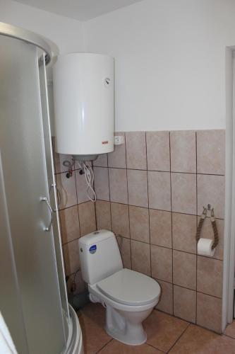 een badkamer met een toilet en een watertank bij White box apartment in Liepāja