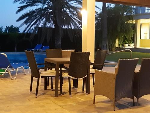 a table and chairs on a patio with a pool at Secret Garden Residence in Paphos
