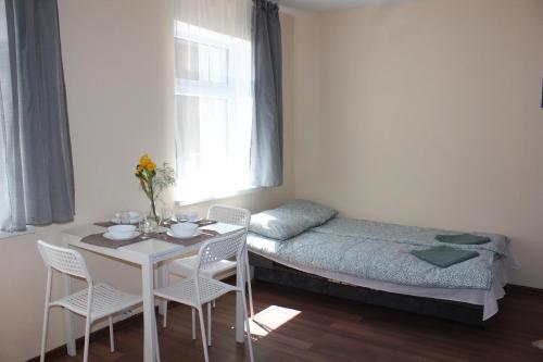 una camera con letto, tavolo e sedie di White box apartment a Liepāja