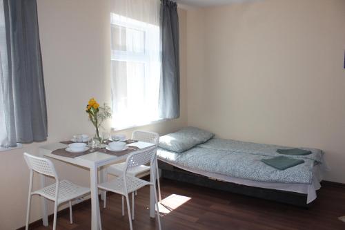 een kamer met een bed, een tafel en stoelen bij White box apartment in Liepāja