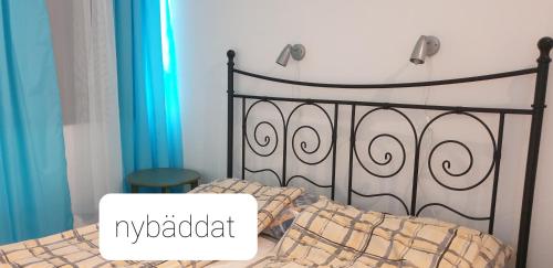 een slaapkamer met een zwart bed en een bord met mykadiadi bij Blankaholm 25 in Blankaholm