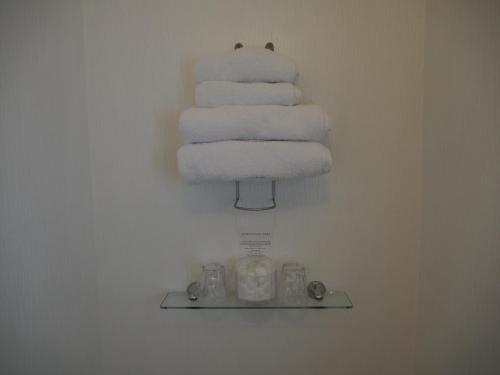 a stack of towels on a shelf in a bathroom at Montfort Cottage Guest House in Windermere