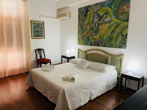 a bedroom with a bed with a painting on the wall at CASA DEL CORSO in Cinisi