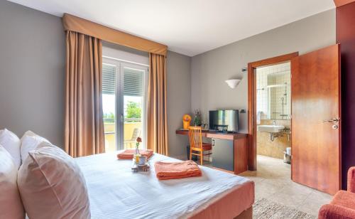 a bedroom with a large bed and a television at Hotel Podstine in Hvar