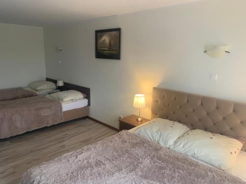 sypialnia z 2 łóżkami i lampką na stole w obiekcie Villa Marina w mieście Dąbki