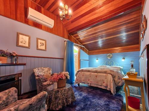 1 dormitorio con 1 cama, mesa y sillas en Verde que te quero Ver-te - Chalés, en Visconde De Maua