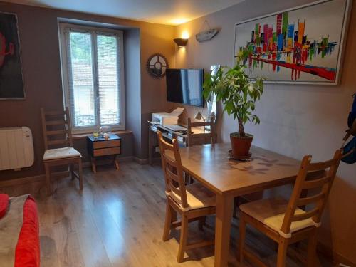 uma sala de estar com uma mesa e uma secretária com uma planta em Le saquet em Ax-les-Thermes