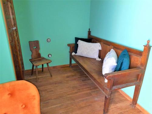 a room with a bench with pillows and a chair at Casa Rural del Tío Maino in Becerril de la Sierra