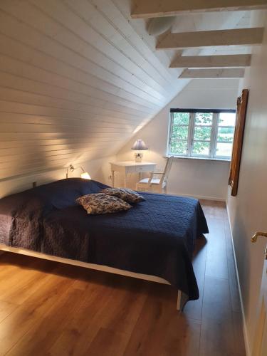 Schlafzimmer mit einem Bett, einem Schreibtisch und einem Fenster in der Unterkunft Lillevang bed & breakfast in Sorø