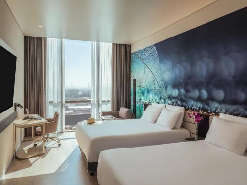 a hotel room with two beds and a large window at Novotel Mexico City Toreo in Mexico City