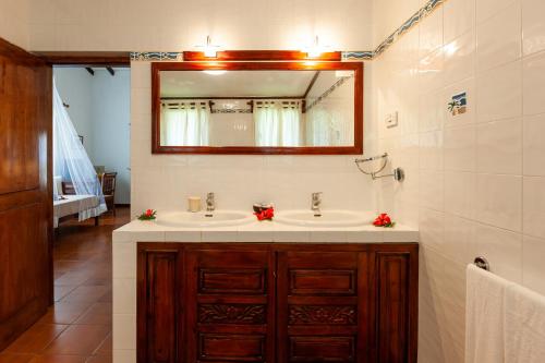 a bathroom with two sinks and a mirror at Hotel Cote d'or Lodge in Baie Sainte Anne