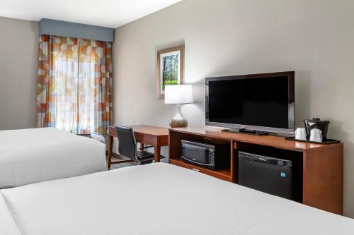 a hotel room with two beds and a flat screen tv at Comfort Inn & Suites in Cleveland