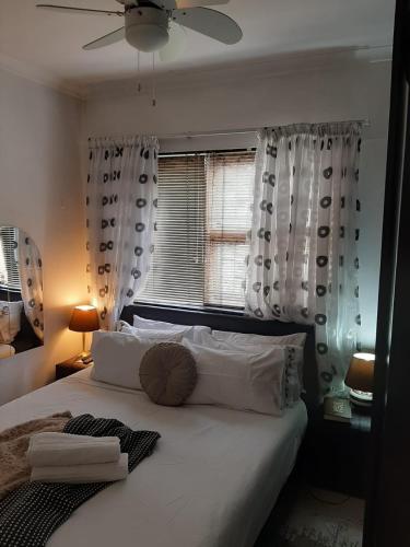 a bedroom with a large white bed with a window at Turning Point Bed & Breakfast in Cape Town