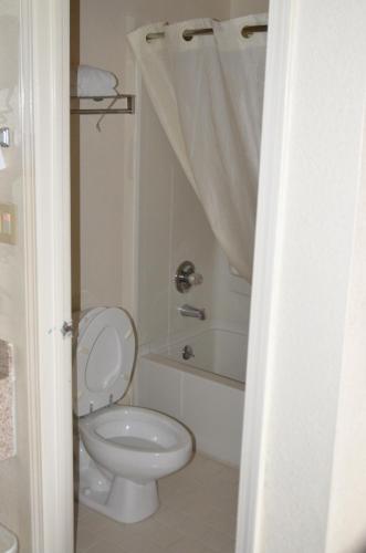 a bathroom with a toilet and a tub and a sink at Motel 6-Covington, TN in Covington