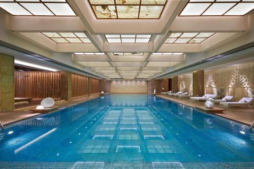 a large swimming pool with blue water in a building at Mandarin Oriental Pudong, Shanghai in Shanghai