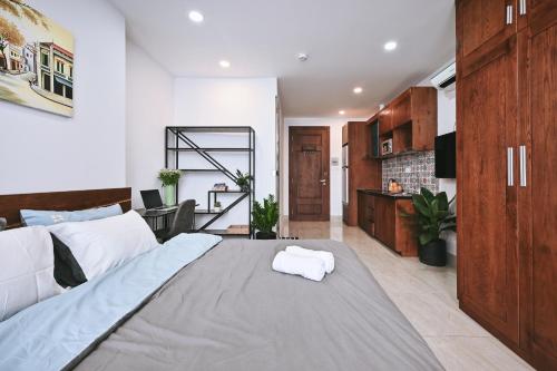 a bedroom with a large bed and a living room at Qhome in Ho Chi Minh City