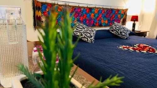 a bedroom with a blue bed with pillows and a plant at Villa Las Campanas in San Juan Teotihuacán