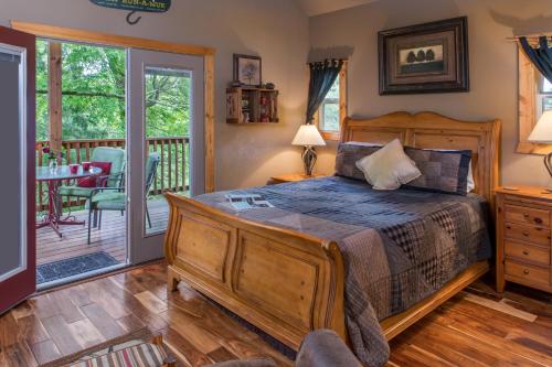a bedroom with a wooden bed and a deck at Eureka Sunset Cabins in Eureka Springs