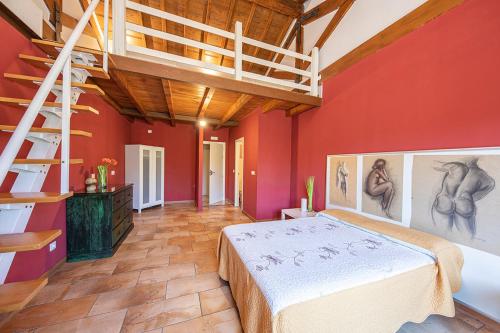 a bedroom with red walls and a bed and a ladder at Apartamentos El Capricho in Águeda del Caudillo