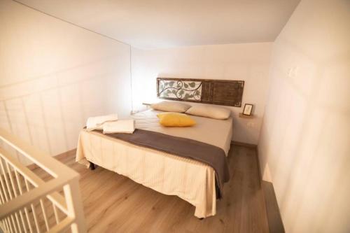 ein Schlafzimmer mit einem Bett mit gelbem Kissen darauf in der Unterkunft Relais San Mamaso-Centro Storico in Verona