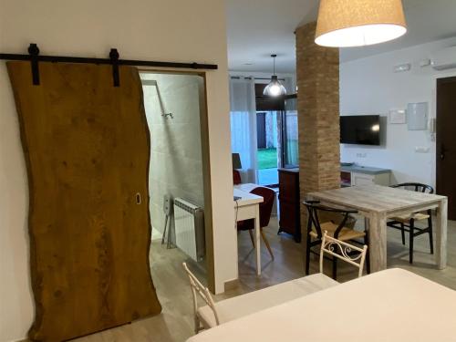 a living room with a table and a sliding door at Apartamentos rurales Posada de Monfragüe con jacuzzi in Malpartida de Plasencia