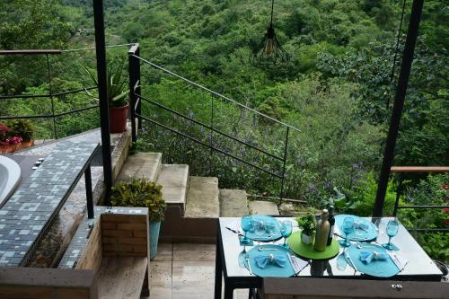 a table with wine glasses on a balcony with stairs at Hotel Casa Ambrosia in Villeta