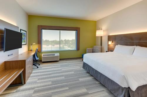 a hotel room with a bed and a flat screen tv at Holiday Inn Express - Wilmington - Porters Neck by IHG in Wilmington