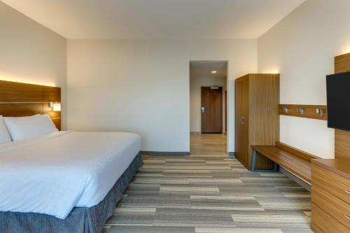 a hotel room with a bed and a flat screen tv at Holiday Inn Express - Wilmington - Porters Neck by IHG in Wilmington