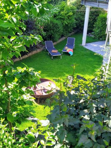 two chairs and a fire pit in a yard at Entspannen im Grünen, Ferienwohnung mit eigenem Garten in Keilberg