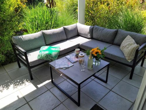 a couch and a table on a patio at Entspannen im Grünen, Ferienwohnung mit eigenem Garten in Keilberg