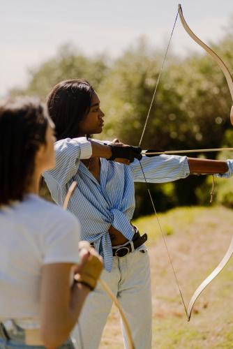 a woman is holding a bow and arrow at Aethos Saragano in Saragano
