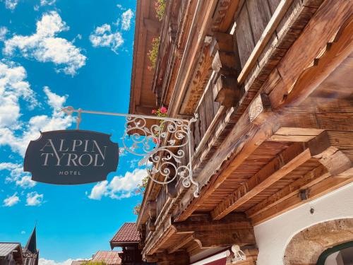 a sign hanging on the side of a building at Hotel Alpin Tyrol - Kitzbüheler Alpen in Sankt Johann in Tirol
