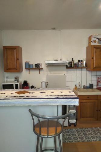 une cuisine avec un comptoir et une chaise dans l'établissement Le charme du centre ville et l ambiance plage, à Châtelaillon-Plage