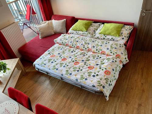 a bedroom with a bed and a red couch at KUBO TATRY - Starý Smokovec in Smokovce