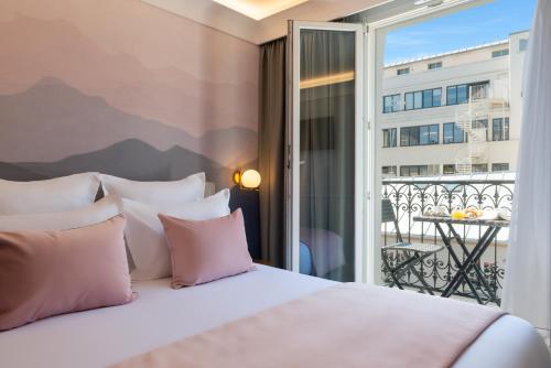um quarto com uma cama e vista para uma varanda em Hôtel Le Milie Rose em Paris