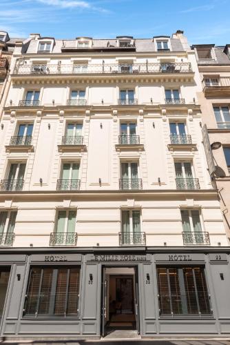 a large white building with windows and a door at Hôtel Le Milie Rose in Paris