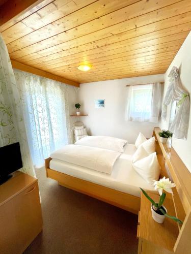 a bedroom with a large bed with a wooden ceiling at Apartments Spirit of Mountains in Rasun di Sopra