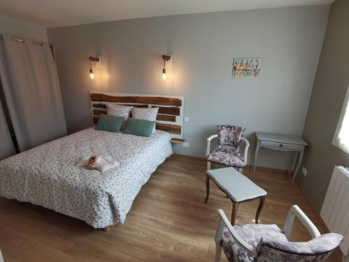 a bedroom with a bed and a table and chairs at Les Hauts de Grazac in Grazac