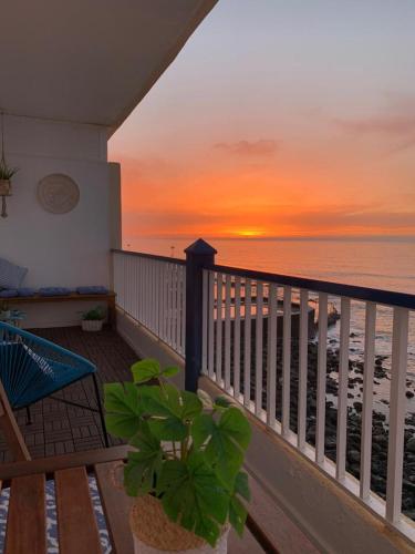 a balcony with a view of the beach at sunset at Hola ola Bajamar in Bajamar