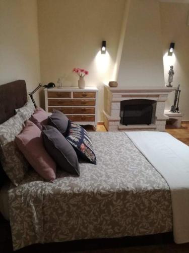 a bedroom with a bed with pillows and a fireplace at Família Gaiolas in Marinhais