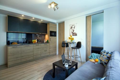 sala de estar con sofá y mesa con ordenador portátil en W&K Apartments - Compact I en Koszalin