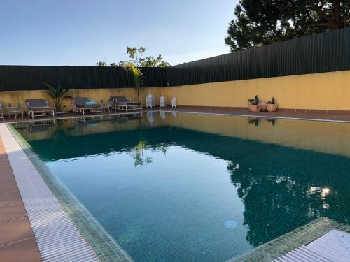 a swimming pool with blue water in front of a building at Villa Mar Azul in Albufeira