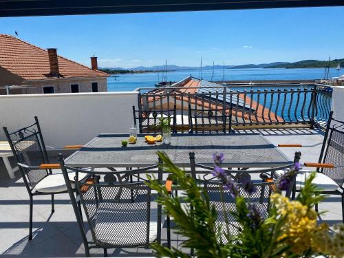 a table and chairs on a balcony with a view of the water at Villa Adria in Vodice